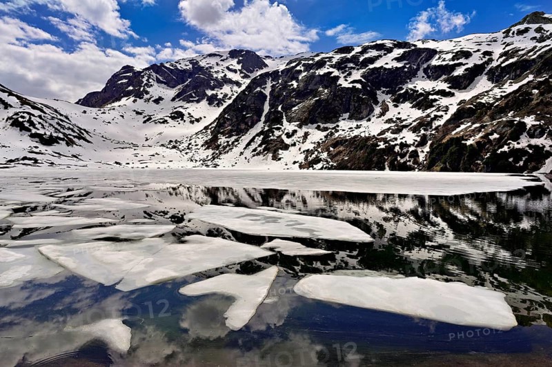 Ice floes float in the half-frozen Upper Murgsee, Murgtal, Canton of St. Gallen, Switzerland