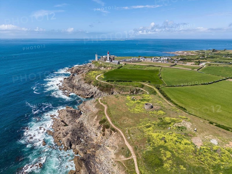Aerial view of the distinctive red and white lighthouse Phare de Saint-Mathieu on the Breton coast next to the historic church ruins of the former Benedictine Abbey of Saint-Mathieu de Fine-Terre, next to it a white marine signal tower also called Sémaphor, Pointe Saint-Mathieu, Plougonvelin, Finistère department, Brittany region, France