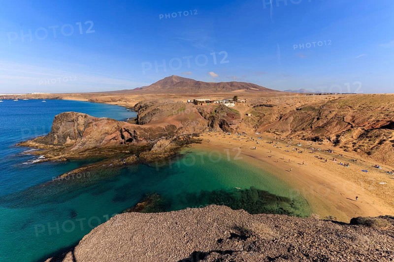 Lanzarote, Canary Islands, Spain, Europe, Playas de las Papagayo, A sunlit beach with turquoise water and cliffs, a mountain in the background