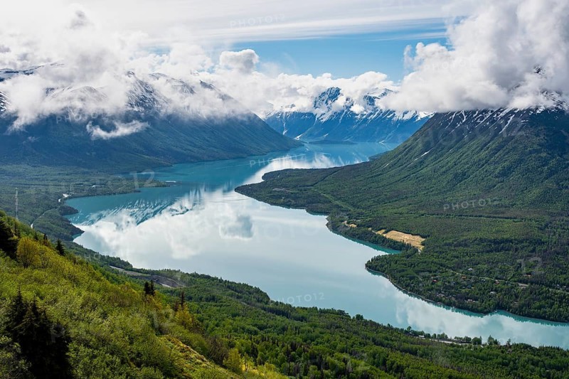 View of snowy mountains in spring and turquoise Kenai Lake with reflection, Slaughter Ridge Trail, Cooper Landing, Kenai Peninsula, Alaska, USA