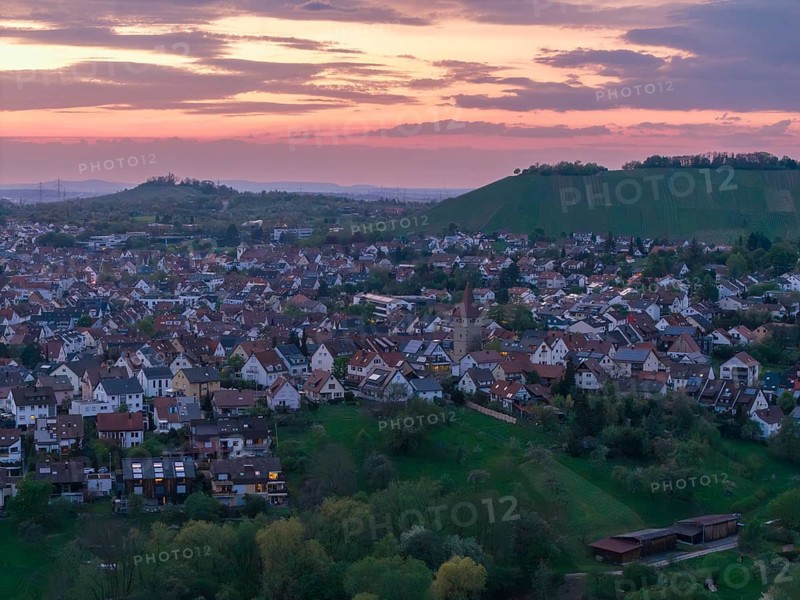 Landscape with many houses at dusk surrounded by rolling hills and a pastel-coloured sky, Korb im Rems Valley, Baden-Württemberg, Germany