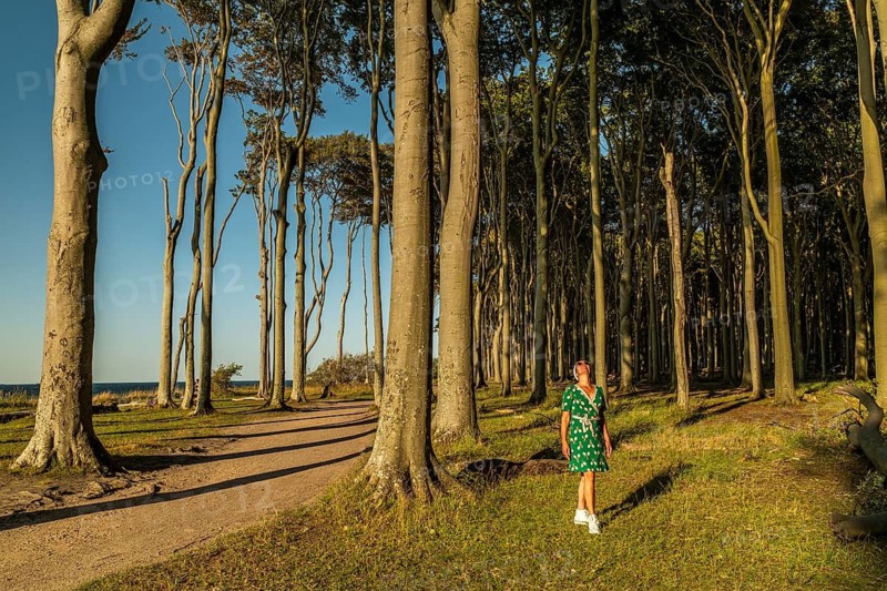 A woman (54) wearing a green tennis dress and white shoes in the Gespensterwald, Nienhagen, Germany