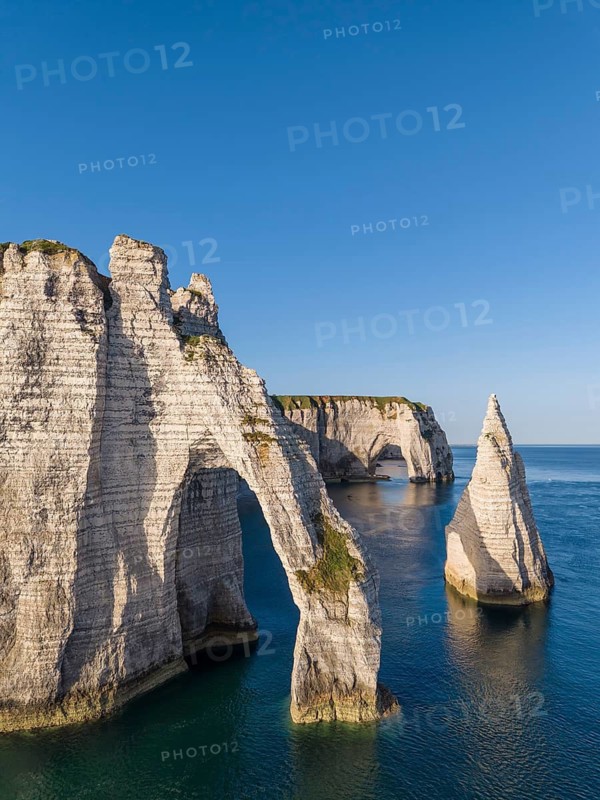 Aerial view of the Porte d'Aval rock formation with the free-standing Aiguille d'Étretat rock pin in the morning sun, well-known sights and natural beauty on the chalk coast, behind it the La Manneporte rock gate, Étretat, Alabaster Coast, La Côte d'Albâtre, chalk cliffs, English Channel, Seine-Maritime, Normandy, France