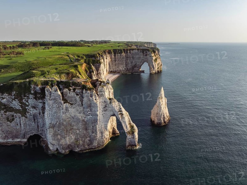 Aerial view of the Porte d'Aval rock formation in the evening sun, well-known sights on the chalk coast with the distinctive rock needle, behind it the La Manneporte rock formation, right on the cliffs of the Golf d'Étretat golf course founded in 1908, Alabaster Coast, La Côte d'Albâtre, chalk cliffs, English Channel, Seine-Maritime, Normandy, France
