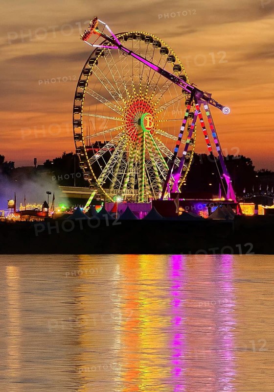 Rheinkirmes, largest funfair on the Rhine in a colorful sunset with a view over the river, Düsseldorf, North Rhine-Westphalia, Germany