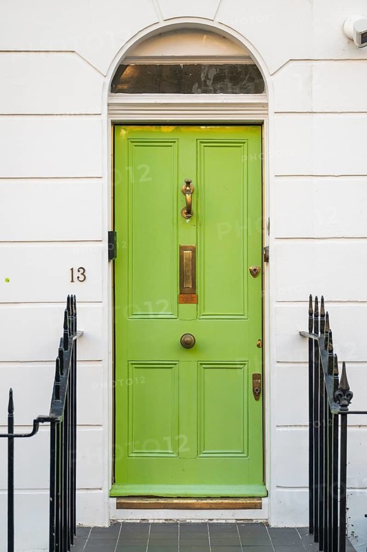 Light green front door with gold fittings in white house facade surrounded by black metal railing, Borough of Chelsea and Kensington, London, England, Great Britain, Great Britain