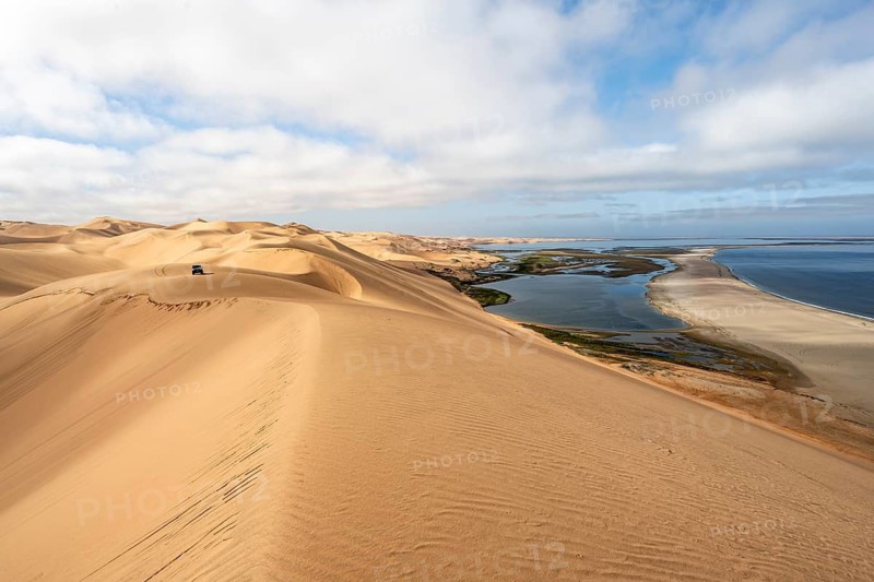 Sand dunes and sea in morning light, Atlantic coast and Namib desert, impressive desert landscape, view of Sandwich Harbour lagoon, Namib Naukluft Park, Namibia