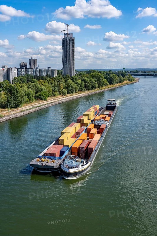 Low water in the Rhine near Cologne, looking north, Mülheimer Rheinbrücke, container freighter Melizzo, in the paddock, push association, due to the distribution over 3 parts of the ship, the draft is not as large and a larger quantity of freight, containers, can be transported at the same time, inland shipping is severely restricted, only a few ships sail, then with a significantly reduced load, on the day of recording it was the lowest ever measured Rhine level in Cologne, 60 cm, Colonia House, high-rise residential building in Cologne-Riehl, 147 meters high, North Rhine-Westphalia, germany