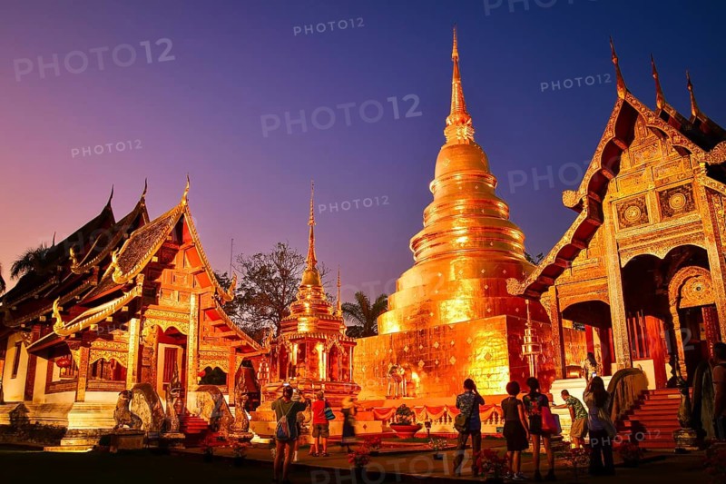 Chiang Mai, Thailand - 4th february, 2025: Wat Phra Singh Woramahawihan.Tourists visiting the golden chedi and Lanna - style temple buildings illuminated sunset twilight blue hour