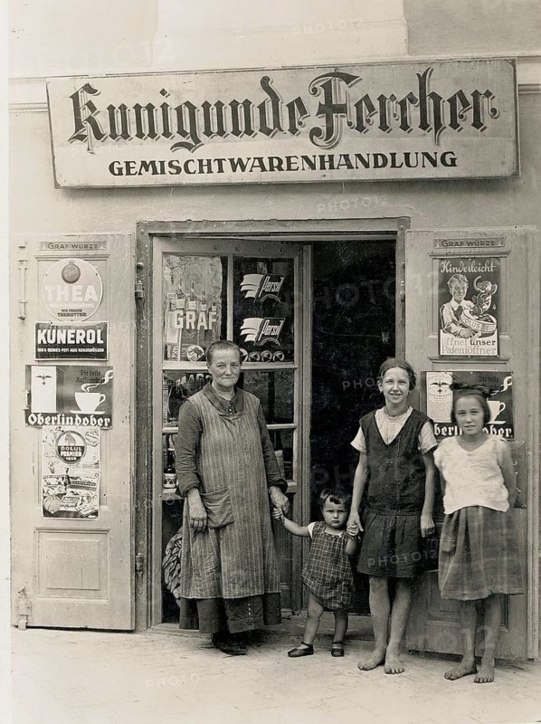 Vienna, shop, general store, Kunigunde Fercher, Kunerol, advertising signs, girl, child, black and white photo of a family in front of a general store with various information signs, around 1920