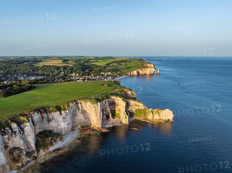 Aerial view of the Porte d'Amont rock formation, Falaise d'Amont shortly after sunrise, a landmark and natural beauty on the chalk coast with the distinctive rock gate, behind it the holiday resort of Étretat with the beach, on the right the Porte d'Aval rock formations, Alabaster Coast, La Côte d'Albâtre, chalk cliffs, English Channel, Seine-Maritime, Normandy, France