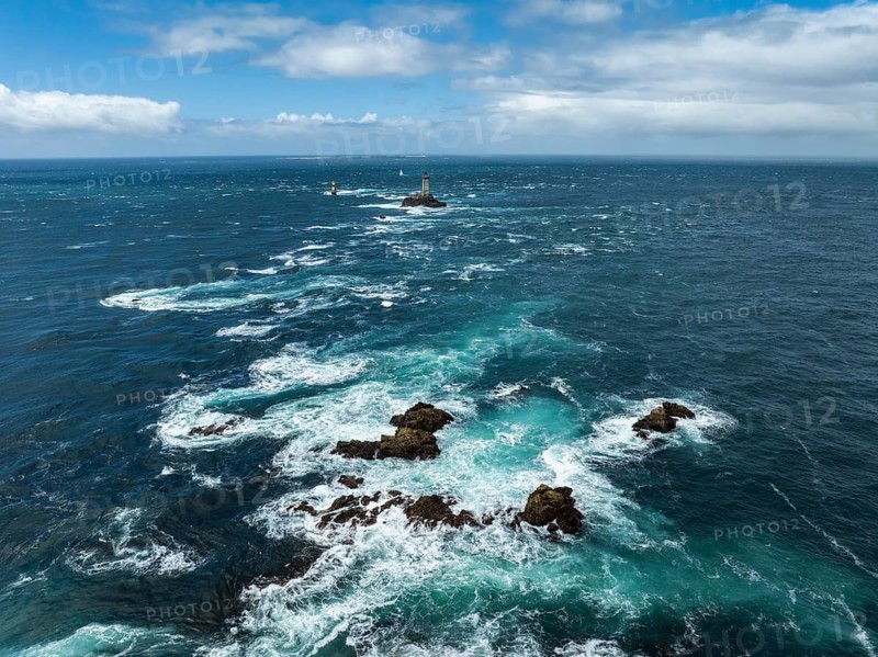 Aerial view of the wild foaming sea at Pointe du Raz with the offshore Phare de la Vieille lighthouse on a rocky island in the rough sea road, Raz de Sein, Pointe du Raz, Plogoff, Quimper, Finistère, Brittany, France