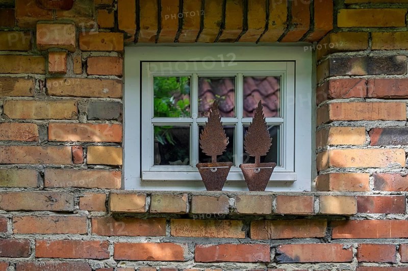 Small lattice window in a rustic brick façade, metal decoration on window ledge, North Rhine-Westphalia, Germany