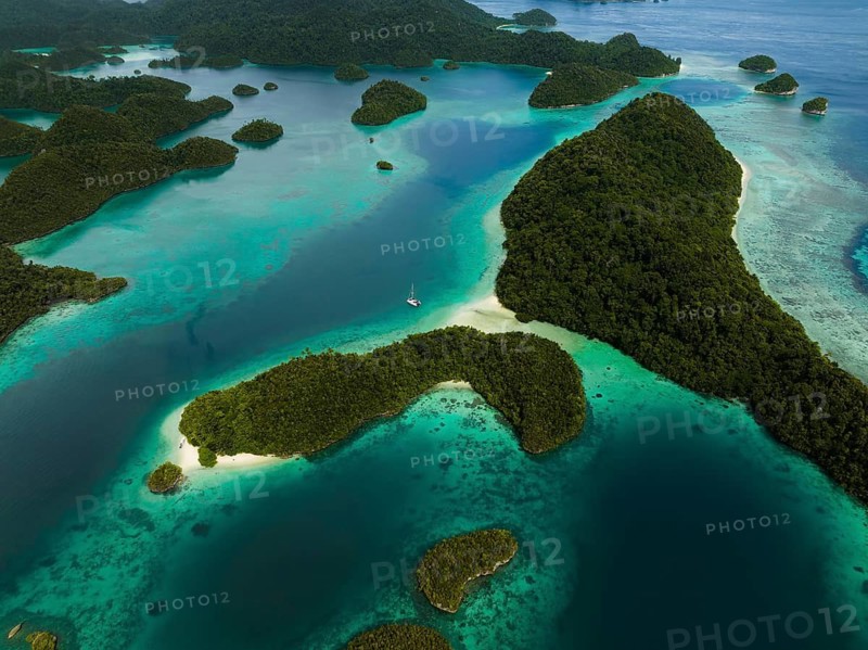 Aerial view of a sailboat surrounded by tropical islands and turquoise lagoons, Wayag Archipelagio, West Papua, Indonesia