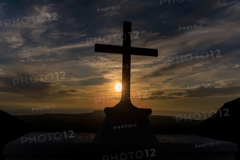 Lanzarote, Canary Islands, Spain, Europe, Femes at the Ermita de San Marcial de Rubicon, A cross in silhouette against a calm sunset sky over the ocean