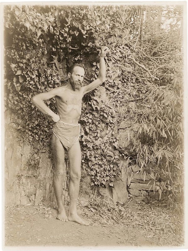 Lebensreform, man, 10-day fast, ascetic, A bearded man with minimal clothing poses thoughtfully in front of thick leaves, around 1926