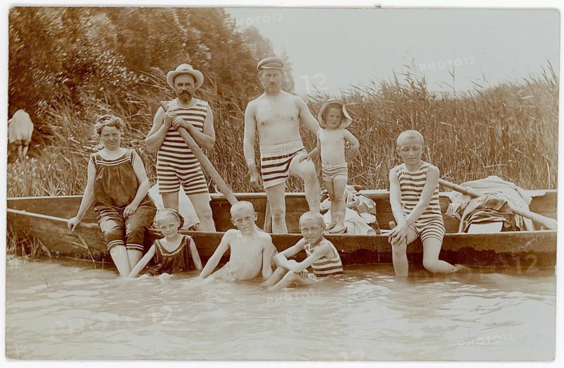 Bathing, swimwear, woman, men, children, leisure, fun, summer, A family in striped bathing suits posing in a boat on a lake, around 1918