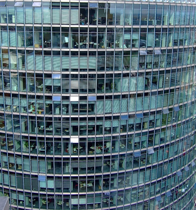 Tall office building complex with many windows that provide insights into various offices, Berlin, Germany