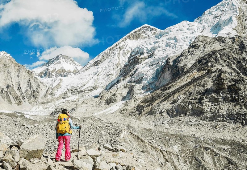Woman trekker alone stands by EBC viewpoint in Sagarmatha national park with mountains background. EBC trekking. Everest base camp trekking. Khumbu icefall panorama