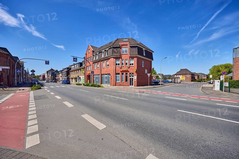 Residential and commercial buildings, brick architecture, general architecture, discount store, Netto brand discount, sidewalk, street, bicycle path, pedestrian crossing, zebra crossing, trees, blue sky, cirrus clouds, intersection of Issumer Tor, Friedrich-Spee-Straße and Egmondstraße, Geldern, Kleve district, North Rhine-Westphalia, Germany