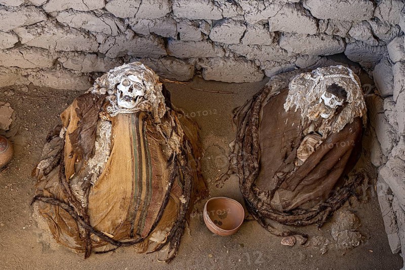 Mummy bundle wrapped in cloth, textiles, grave goods, ancient clay vessels, burial chamber, Nazca culture, Chauchilla, Cementerio Chauchilla, Nazca, southern Peru, Peru, South America