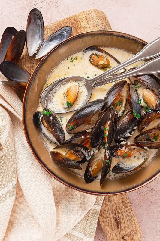 Mussels in creamy garlic sauce, served with fresh herbs and spices, homemade, no people