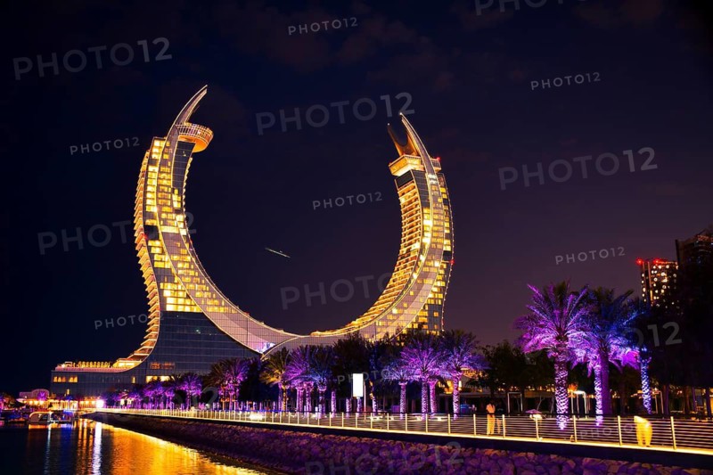 Doha, Qatar - january 6th, 2026: katara Towers at night in Lusail, Qatar. Tourists stroll along the neon-lit Marina Promenade, iconic crescent architecture and reflections.City of the future