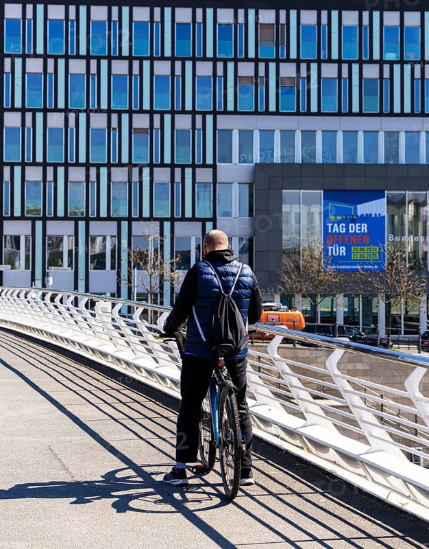 Cyclists on the Crown Prince Bridge with a view of the House of the Federal Press Conference, Government District Berlin, Germany