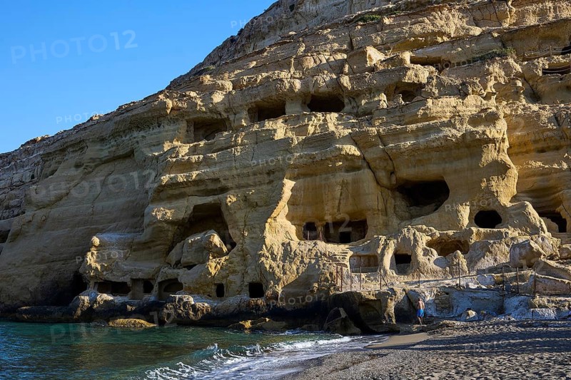 Neolithic caves, former hippie paradise, impressive rock wall with caves on the beach in sunlight, Matala, south coast, Crete, Greek Islands, Greece
