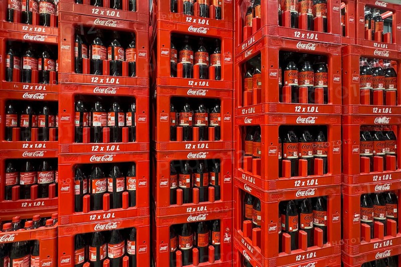 On the left two rows in boxes 1 liter PET bottles recyclable plastic containers polyethylene terephthalate with sugary drink soft drink Coca-Cola Coke Coca Cola with white writing, on the right next to three rows 1 liter bottles stacked in boxes with sugar-free soft drink with black lettering Coca-Cola Zero, also known as Coke Zero, Germany