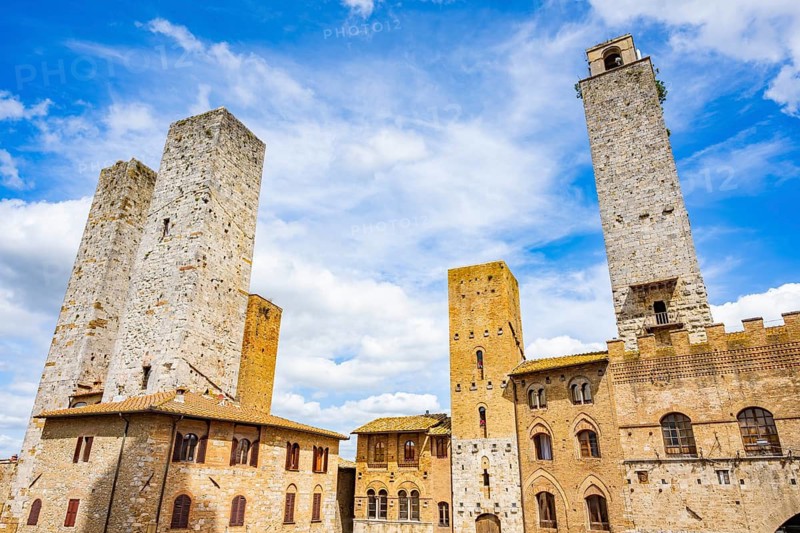 Towers of the old Town with historic buildings from Piazza del Duomo at San Gimignano on a sunny day, Tuscany, UNESCO World Heritage, Italy, Europe, Europe