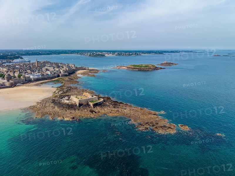 Aerial view of the historic Fort National island fort on the sandy beach of Saint Malo at low tide. On the left is the distinctive city wall, Les Remparts, which encircles the old town center of the corsair town. Côte d'Émeraude, Emerald Coast, Ille-et-Vilaine Department, Brittany, English Channel, France