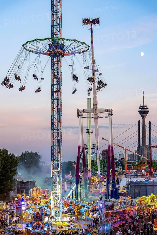Rhine fair in the Rheinwiesen in Düsseldorf-Oberkassel, view towards the Rhine Tower, Rheinkniebrücke, rides, fairground stands, full corridors, lots of visitors, North Rhine-Westphalia, Germany