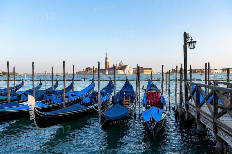 Venetian gondolas, boat launch at St. Mark's Square, San Giorgio Maggiore church in the evening light, Venice, Veneto, Italy