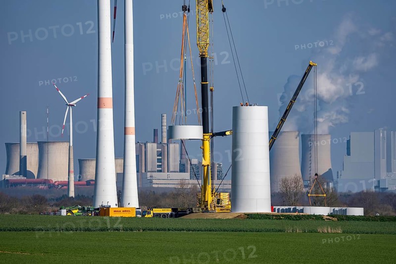 Construction site of the new Bedburg 3 wind farm, on recultivated open-cast mining site, 9 wind power plants with an output of 60 megawatts are newly built, installation of the wind turbine tower, in the background the Neurath lignite power plant, operated by RWE and the city of Bedburg, North Rhine-Westphalia, Germany