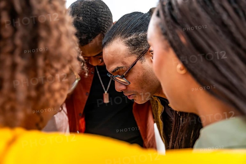 Diverse adults forming a close circle, intently focusing downwards, symbolizing empathy, connection, shared community, and understanding during a mental well being session
