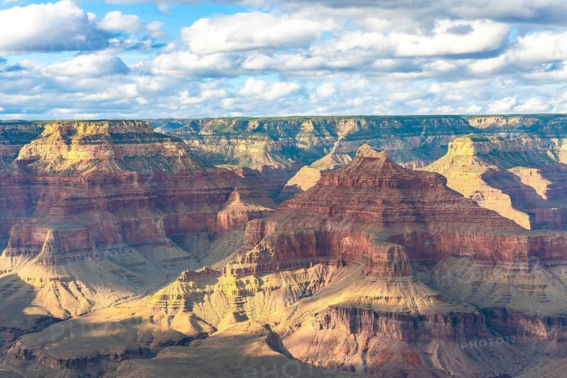Grand canyon national park featuring vast layers of geological rock formations, showcasing the immense scale and natural beauty of the ancient desert landscape under a cloudy sky
