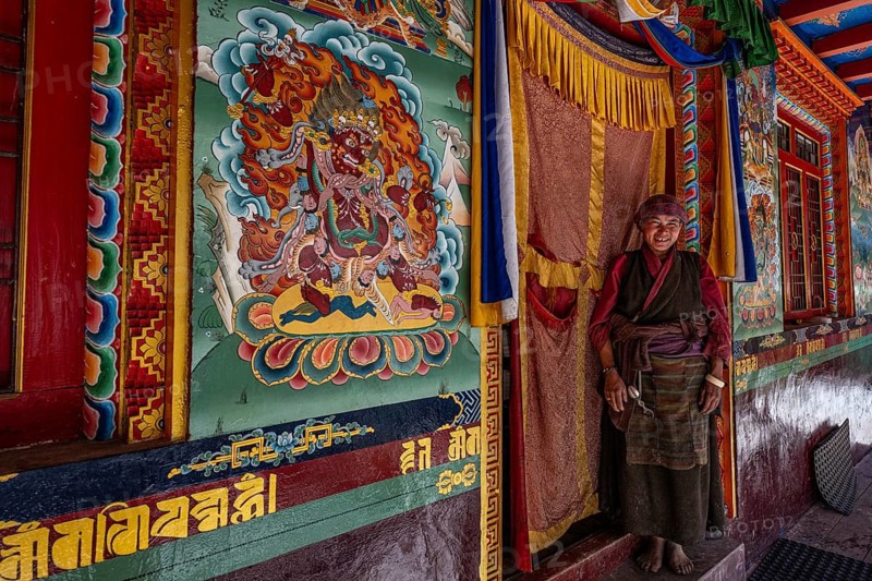 Elderly woman, Buddhist nun in front of Buddhist monastery, Ripchet, Tsum Valley, Himalayas, Nepal