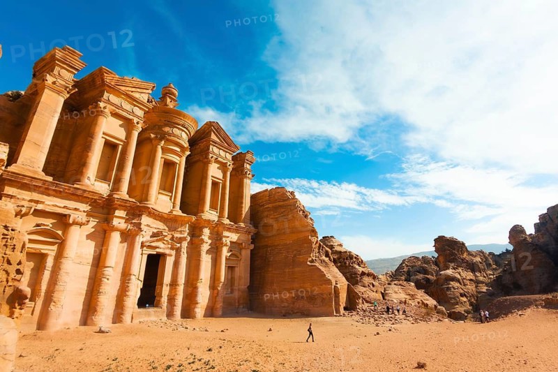 Panorama hilltop Ad Deir Monastery in Petra Jordan. Rock cut Nabataean monument carved sandstone facade UNESCO World Heritage desert landscape in clear sunny autumn day