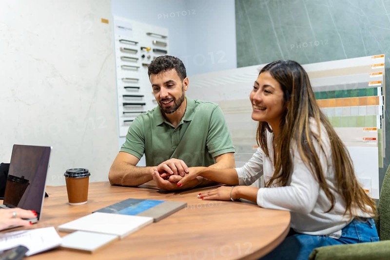 Couple consulting with an expert at a home improvement store, choosing new tiles and materials for an interior design project or house remodel, planning their future home renovation