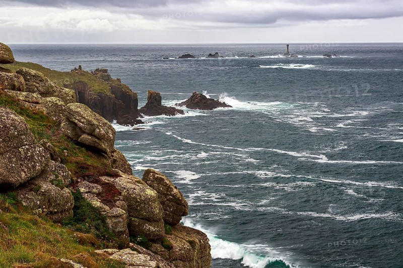The rugged cliffs of Land's End in Cornwall with a view of the historic Longships lighthouse in the Atlantic, Cornwall, southwest England, Great Britain