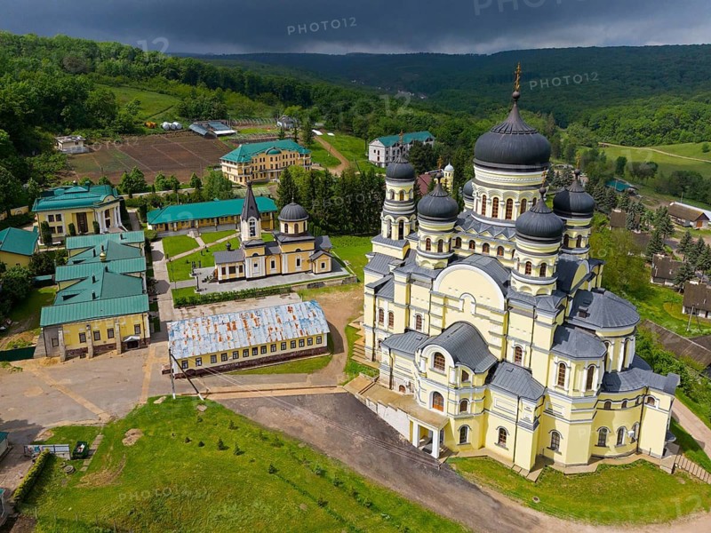 Extensive monastery complex with distinctive yellow buildings and domes under cloudy sky, aerial view, Hîncu monastery, Hâncu, Hâncul, Hincu, Hancu, Hancul, located near the village of Bursuc, Nisporeni district, Republic of Moldova, Moldova