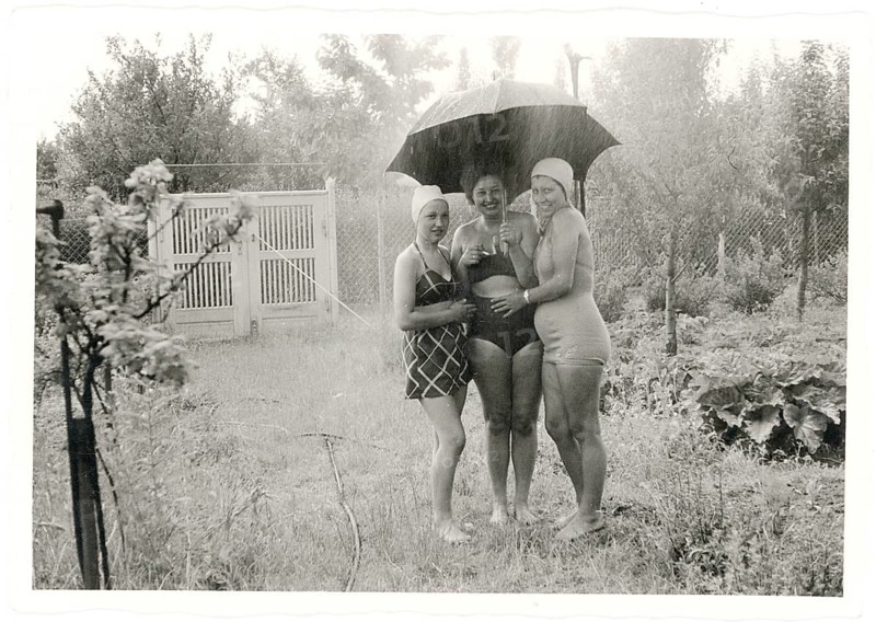 Swimwear, bathing, Three cheerful woman in bathing suits standing under an umbrella in the rain, around 1930