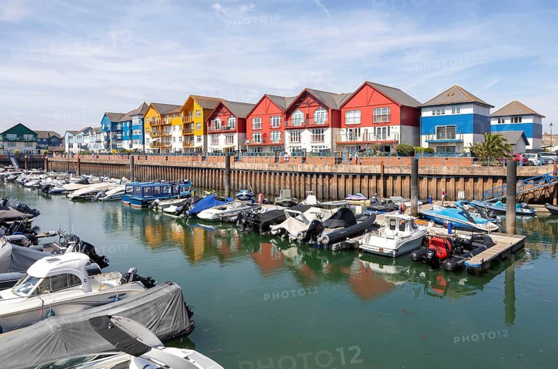 Boats at moorings, modern residential housing development at Exmouth Quay marina, Exmouth, Devon, England, UK
