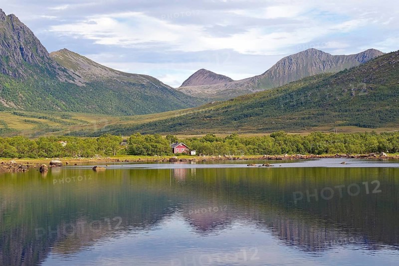 A pink house by the lake with surrounding mountains, Andoeya, Nordland, Vesteralen, Norway