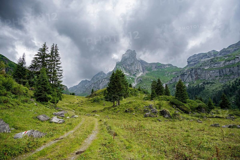 Hiking trail in a valley, rocky peak Spaltenhorn, mountain landscape with dark clouds, Bernese Alps, Bernese Oberland, Switzerland