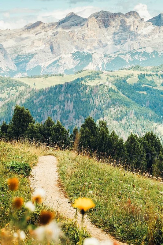 Aerial view Beautiful Dolomites mountain landscape Italy rocky jagged peaks green alpine valley meadows pine trees clouds blue sky scenic summer wilderness nature travel vista