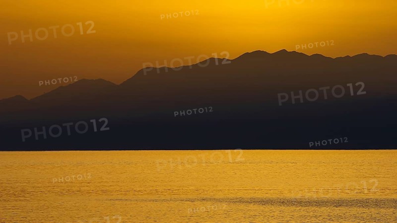 View of sea and mountains at sunset with golden sky, Matala, South Coast, Crete, Greek Islands, Greece