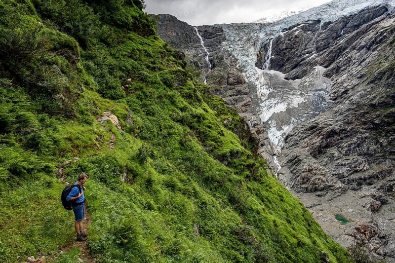 Mountaineers on a hiking trail, cloudy mountain landscape with Grindelwald-Fiescherfirn glacier, Bernese Alps, Bernese Oberland, Switzerland