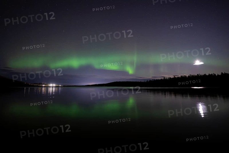 The Northern Lights (Aurora borealis) reflected in a forest lake, Gällivare, Norrbotten, Lapland, Sweden, October 2023